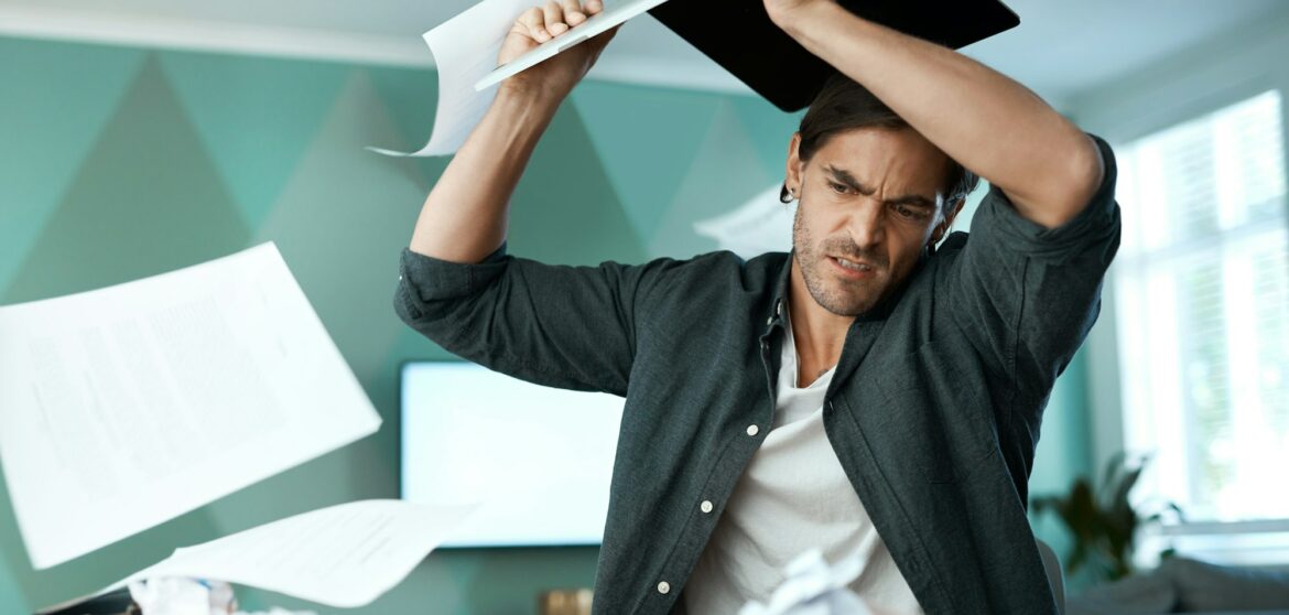 Why is this thing not working. Shot of a young man smashing a laptop on a table at home.