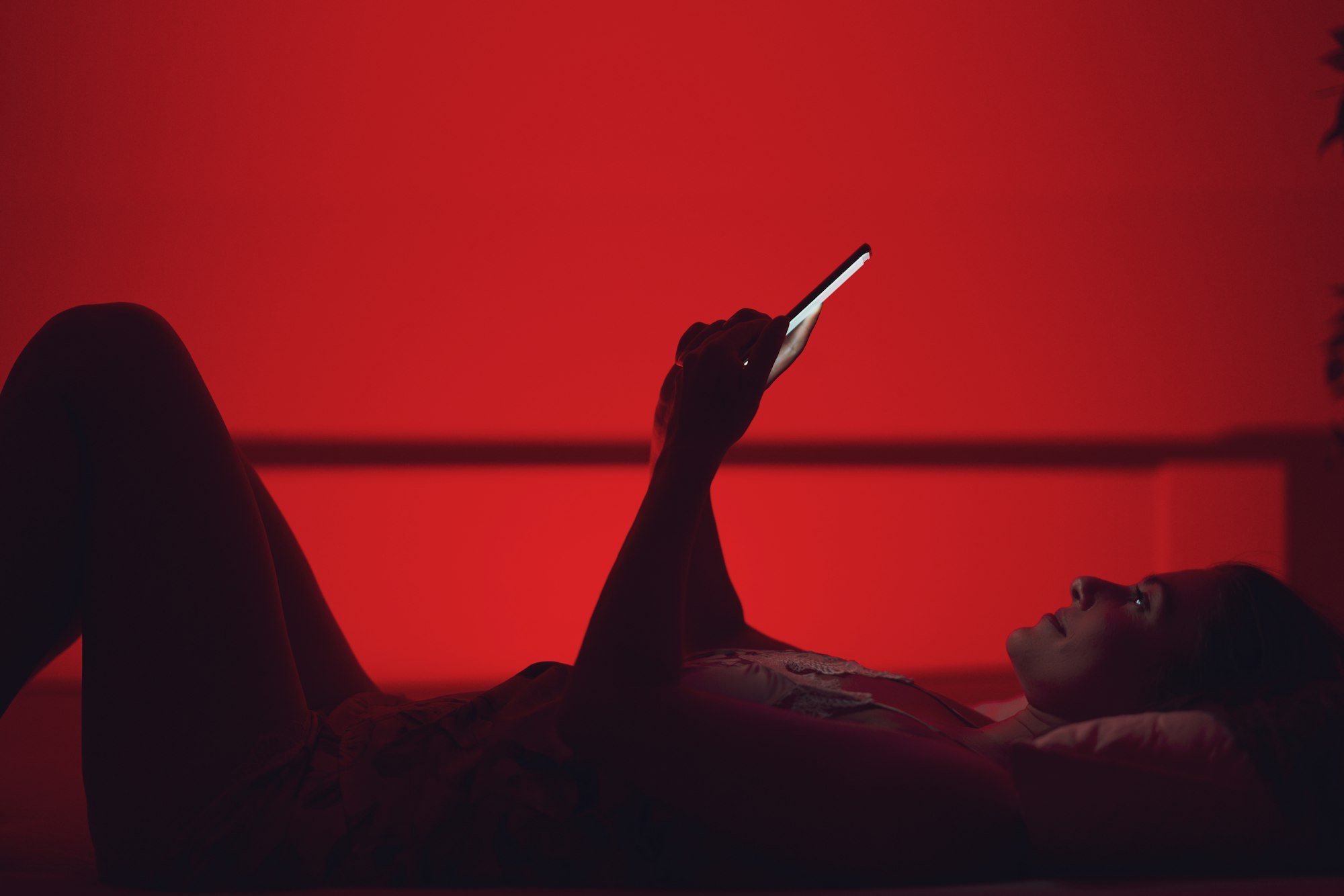 Woman at night in bed with phone